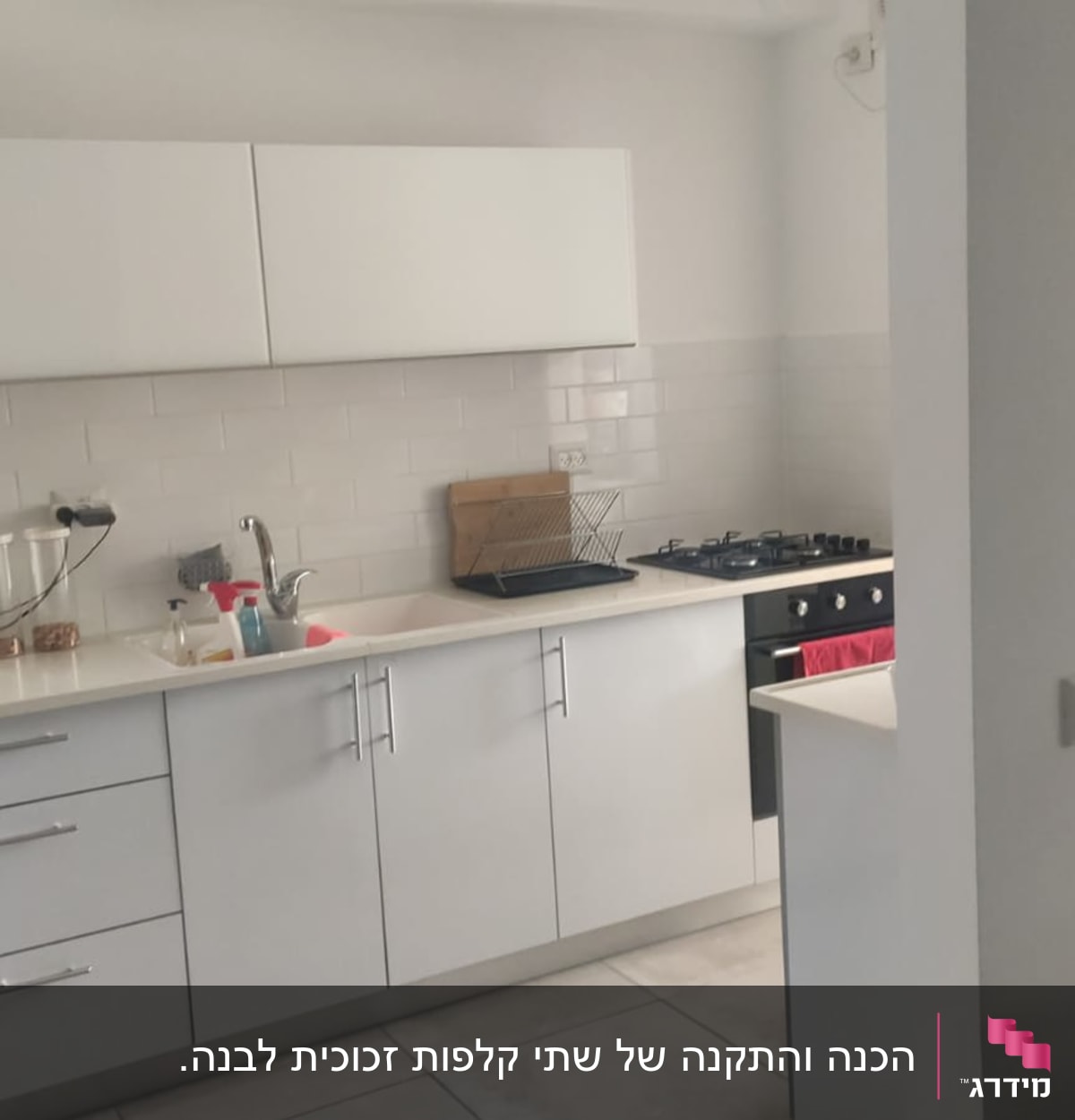 מטבח מודרני עם ארונות לבנים, כיור וכיריים